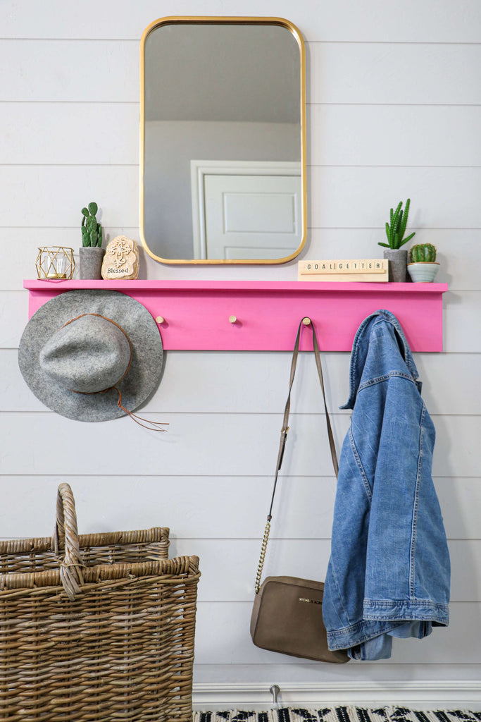 DIY Wall Coat Rack Hanging on a Shiplap Wall under a Gold Mirror with a Hat, purse and jean jacket hanging.