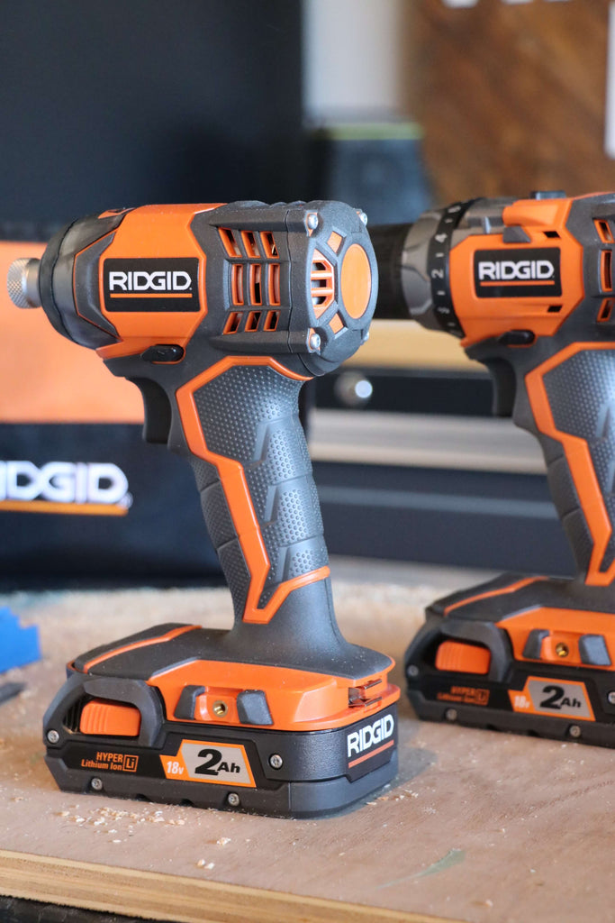 Ridgid 18V Drill/Driver and Impact Driver Combo Kit sitting on a plywood board in front of a RIDGID tool bag